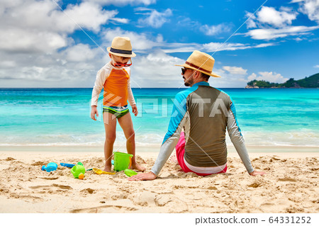 Toddler boy on beach with father Toddler boy on beach with father 64331252