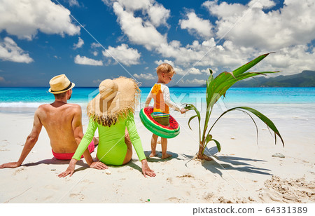 Family with three year old boy on beach. 64331389