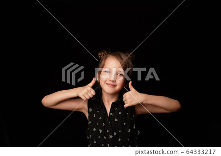 A girl of 6 years, on a black background.Shows gesture sign class, everything will be fine. Fingers up. 64333217