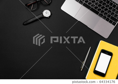 Laptop, smart phone, glasses and watch on black office desk. 64334176