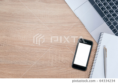 Flat lay of wooden office desk with laptop, smartphone, pen and notebook with copy space background. 64334234