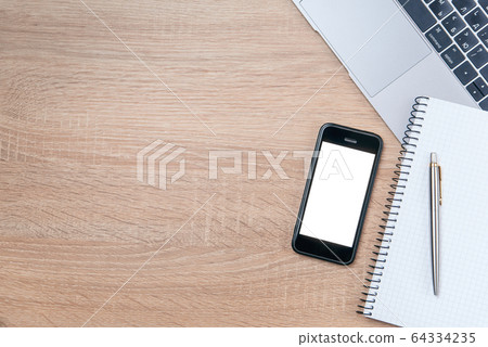 Flat lay of wooden office desk with laptop, smartphone, pen and notebook with copy space background. 64334235