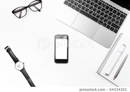 White office desk with laptop and supplies. Top view eyeglasses, watch, smart phone, pen, marker and notebook with free copy space, flat lay. 64334301