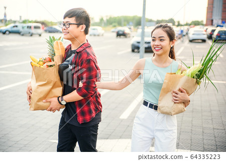 Young Asian couple in love walking in the city after shopping 64335223