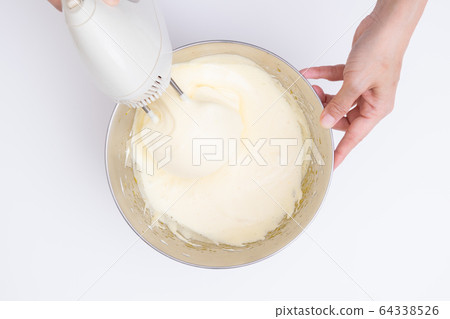 Making sweets at home, sponge dough making process Mixing eggs and sugar with a hand mixer, overhead view Making sweets at home, sponge dough making process Mixing eggs and sugar with a hand mixer, overhead view 64338526