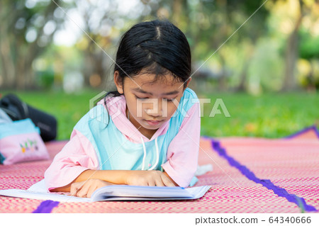 The kid takes a rest outside on the grass The kid takes a rest outside on the grass 64340666