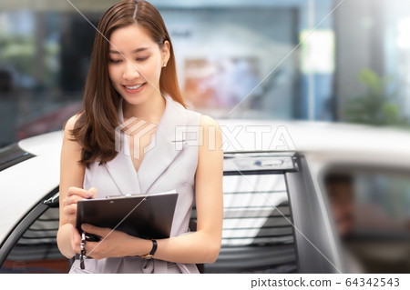 Salesperson working at car dealership.Young Asian Salesperson working at car dealership.Young Asian 64342543