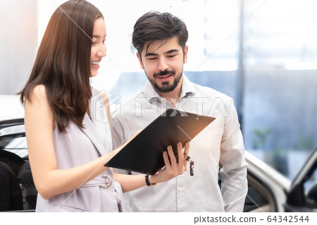 Salesperson working at car dealership.Young Asian Salesperson working at car dealership.Young Asian 64342544