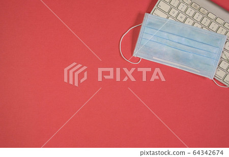 Medical face mask on top of keyboard. Red 64342674