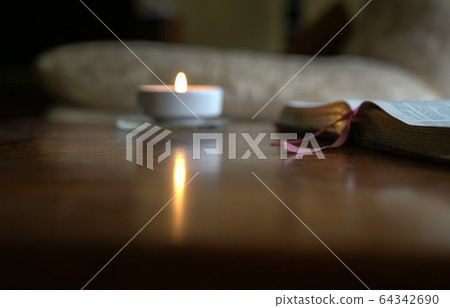 Open bible with burning candle on the table Open bible with burning candle on the table 64342690