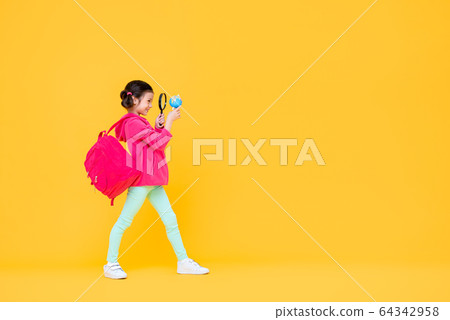 Smiling cute girl use a magnifying lens 64342958