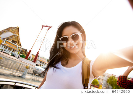 Smiling Asian woman taking selfie at the Giant Swing 64342960