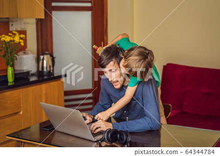 Man is trying to work from home because of the coronovirus epidemic, but his son is stopping him 64344784