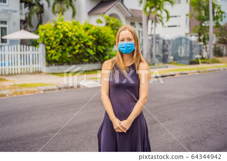 Woman in a small town in a medical mask because of a coronovirus epidemic 64344942