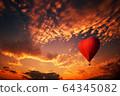 Red hot air balloon in the shape of a heart, Colorful hot-air balloon flying over sunset 64345082