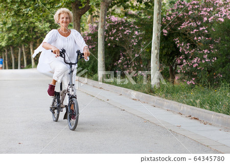 Mature woman cycling Mature woman cycling 64345780