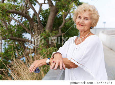 Senior woman relaxing at seaside Senior woman relaxing at seaside 64345783