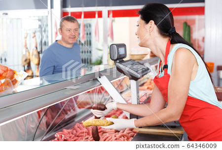 Young seller helping male choosing sausages 64346009
