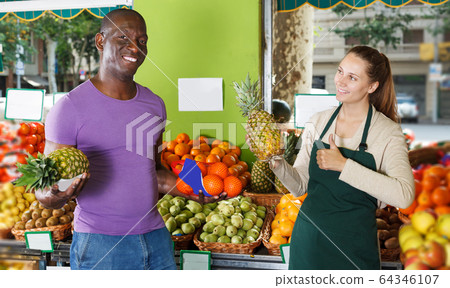 Man is asking from seller about pineapples Man is asking from seller about pineapples 64346107