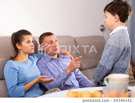 Portrait of upset boy scolded by parents at home 64346142