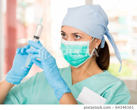 Professional nurse young woman making injection in hospital 64346161