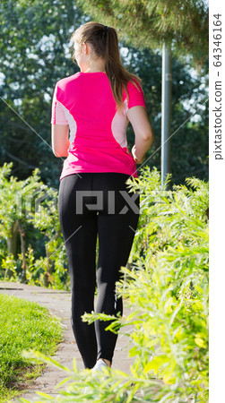 Girl in pink T-shirt is jogging back 64346164