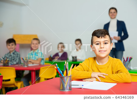 Smiling Hispanic schoolboy at school desk 64346169