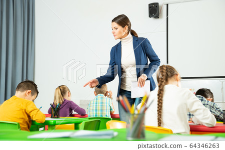 Teacher controlling work of school children Teacher controlling work of school children 64346263