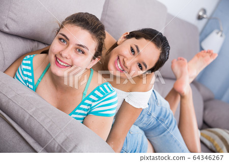 Two happy teenage girls on sofa Two happy teenage girls on sofa 64346267