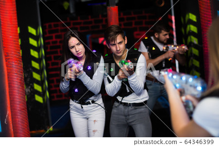 Guy and girl during laser tag game Guy and girl during laser tag game 64346399