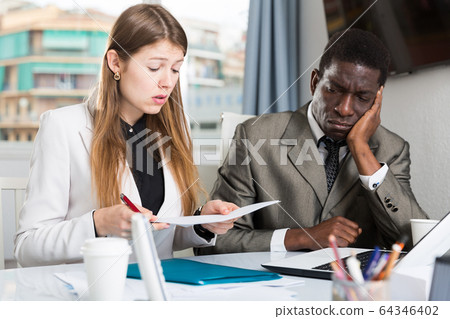 Upset coworkers working together 64346402