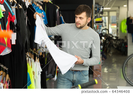 Adult man choosing sport shirt in shop Adult man choosing sport shirt in shop 64346408