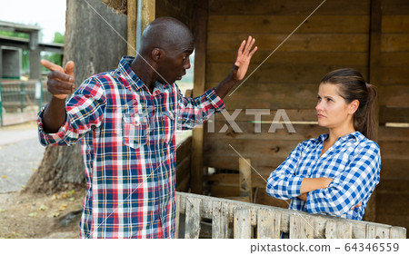 Disgruntled male farmer talking to upset wife Disgruntled male farmer talking to upset wife 64346559