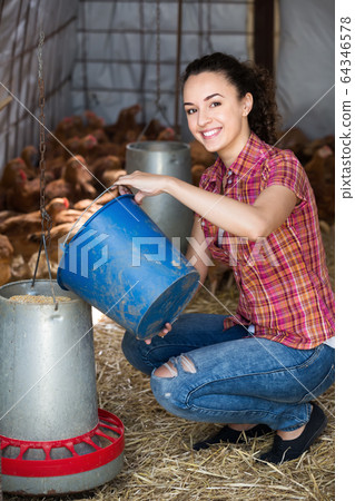 Happy female farmer in farm house 64346578