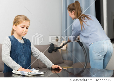 Mother and daughter dusting furniture Mother and daughter dusting furniture 64346579