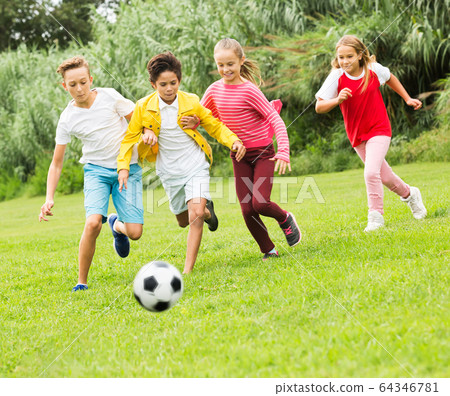 Kids playing football in park Kids playing football in park 64346781