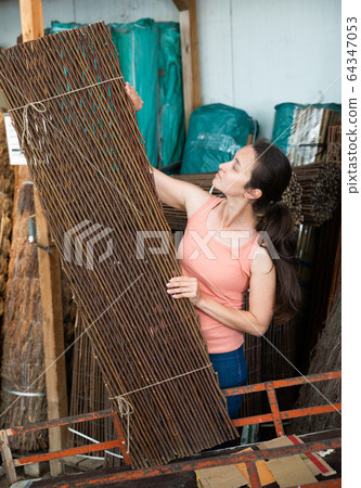 Female customer looking for organic wooden fence for garden Female customer looking for organic wooden fence for garden 64347053