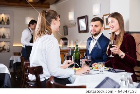 Friends dining at restaurant Friends dining at restaurant 64347153