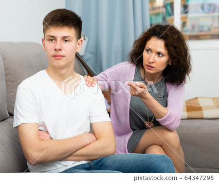 Worried mother talking to son 64347298