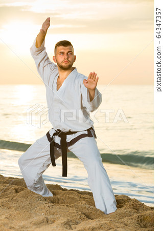 Man 30-40 years old training the Shiko-dachi stance Man 30-40 years old training the Shiko-dachi stance 64347357