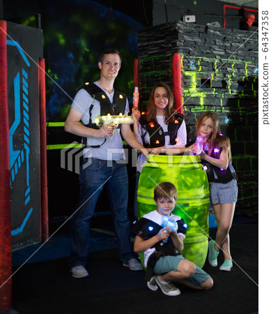 Kds and adults posing with laser guns Kds and adults posing with laser guns 64347358