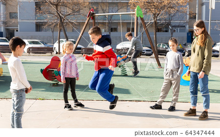 Children skipping on elastic jump rope Children skipping on elastic jump rope 64347444