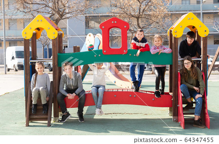 Smiling kids playing together on playground outdoors 64347455