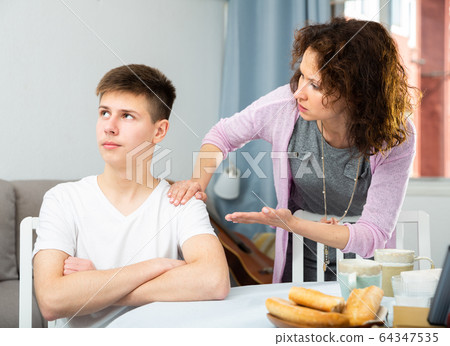 Worried mother talking to son 64347535