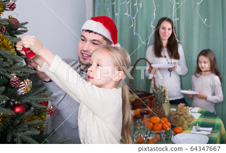 people decorating Christmas tree 64347667