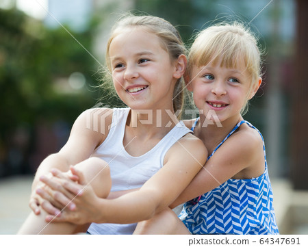 Two small happy sisters outdoors 64347691