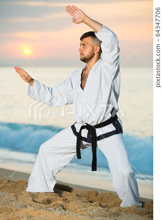Young man is practicing karate moves 64347706