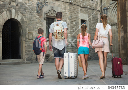 Back view of happy family walking around city Back view of happy family walking around city 64347783