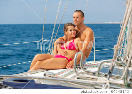 Woman and man on yacht deck 64348143