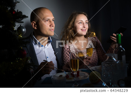 Cheerful couple celebrating New Year Cheerful couple celebrating New Year 64348229